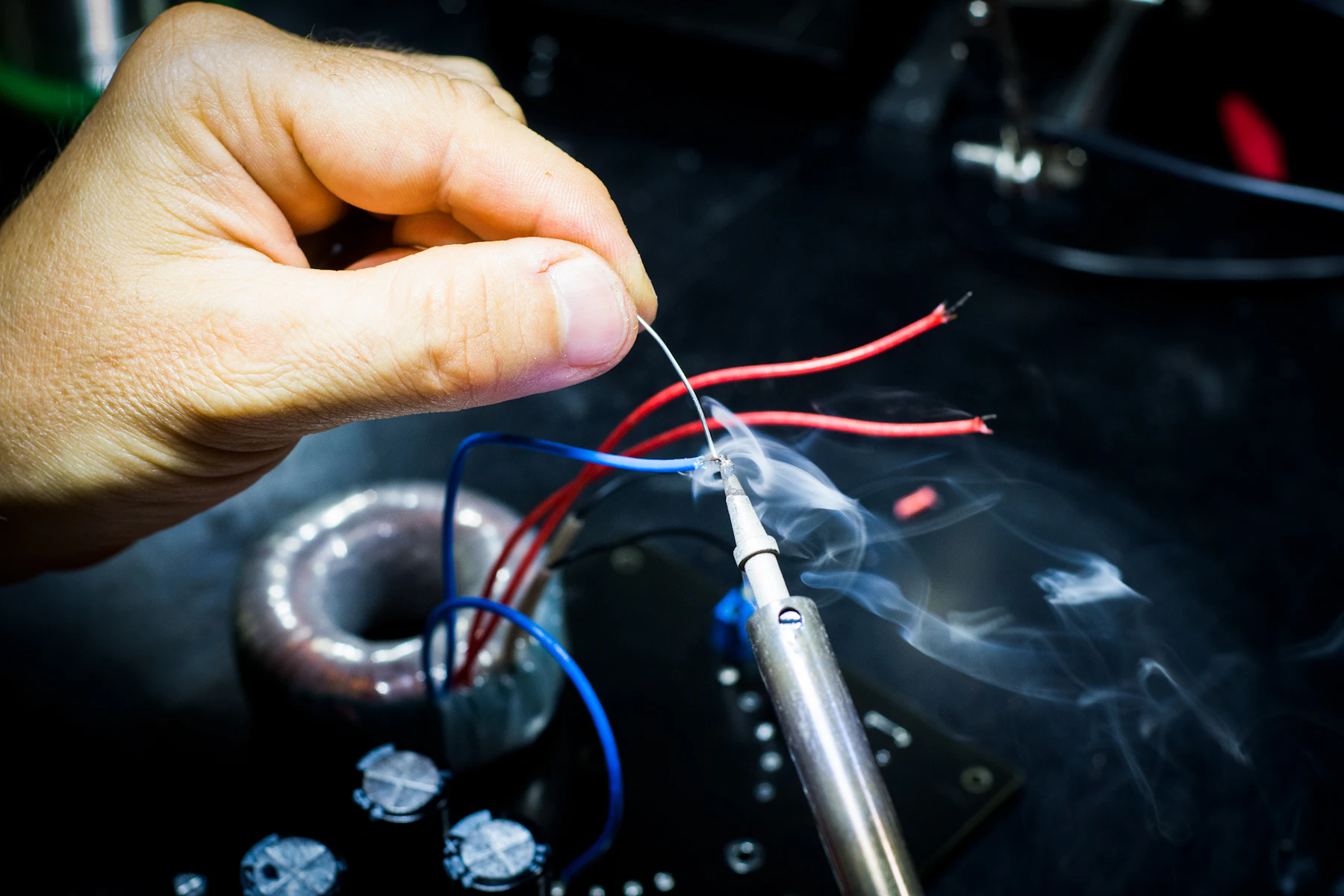 Trabalho manual com solda em uma bancada de eletrônica