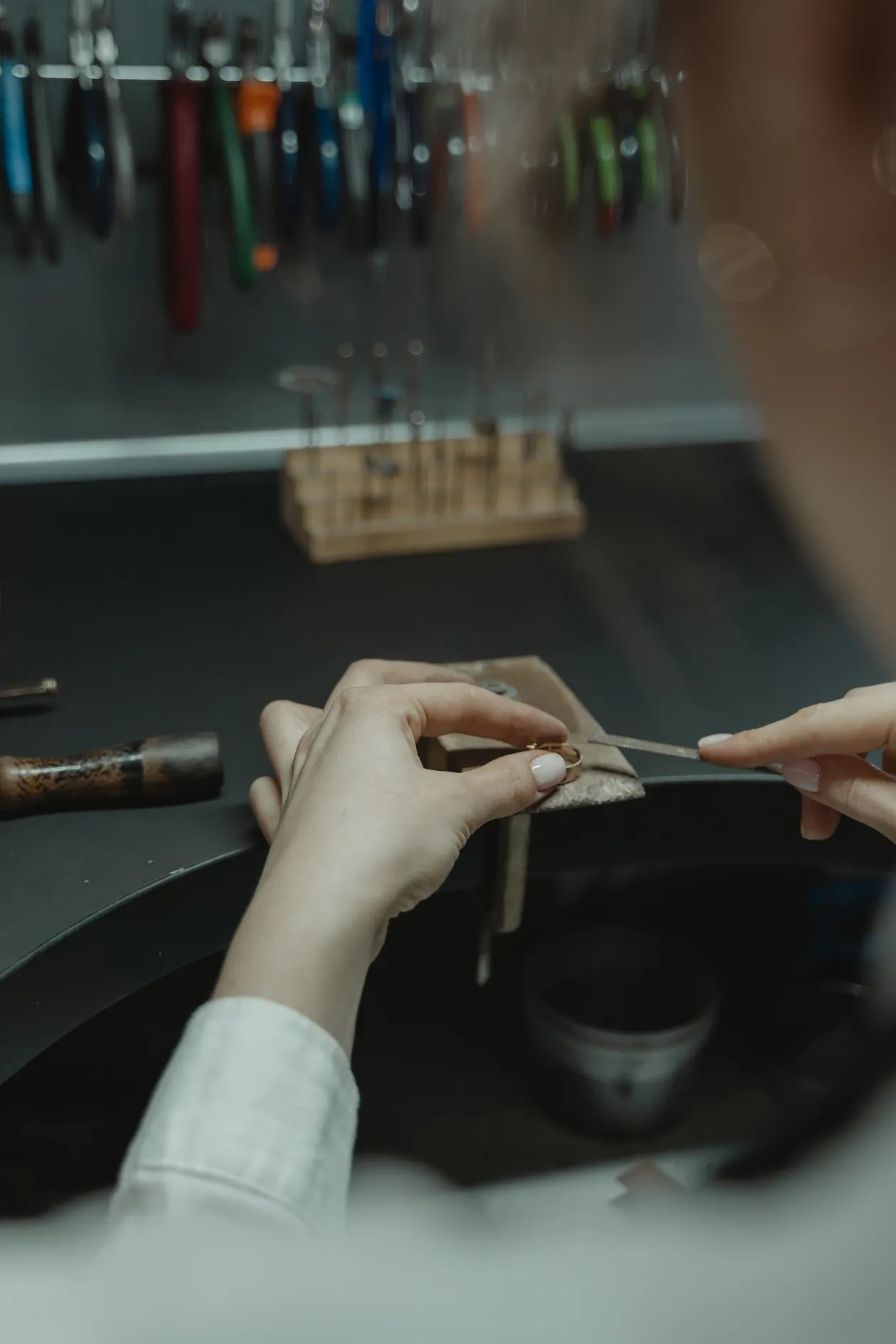 Artesão trabalha em uma bancada com ferramentas e acessórios